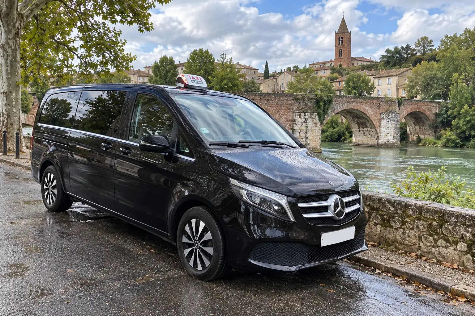 La Classe V de VK Taxi près d’un vieux pont de brique sur l’Ariège, le clocher de l’église au-dessus des toits