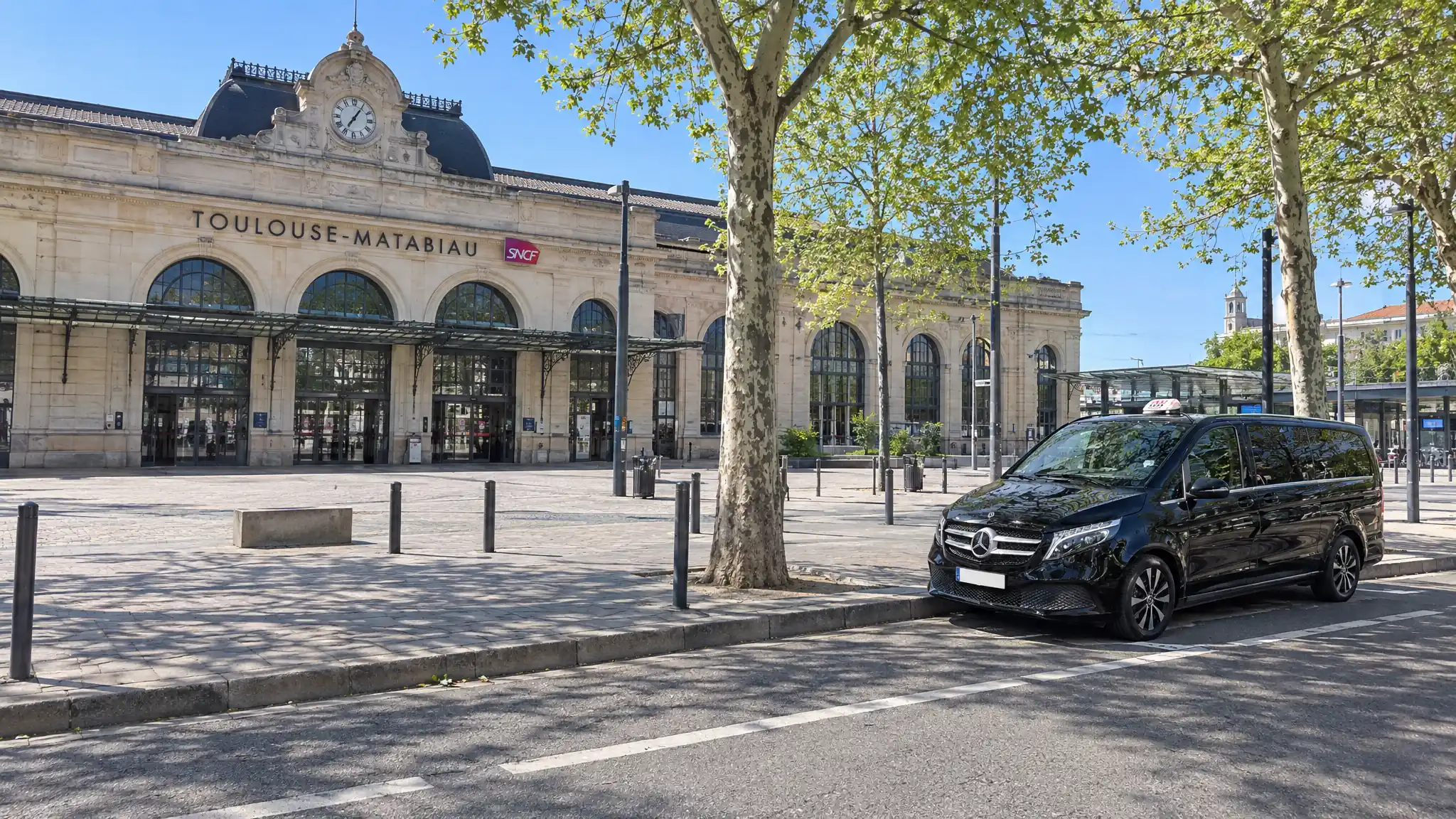 La Classe V de VK Taxi garée devant la façade de la gare Toulouse-Matabiau, un matin de printemps