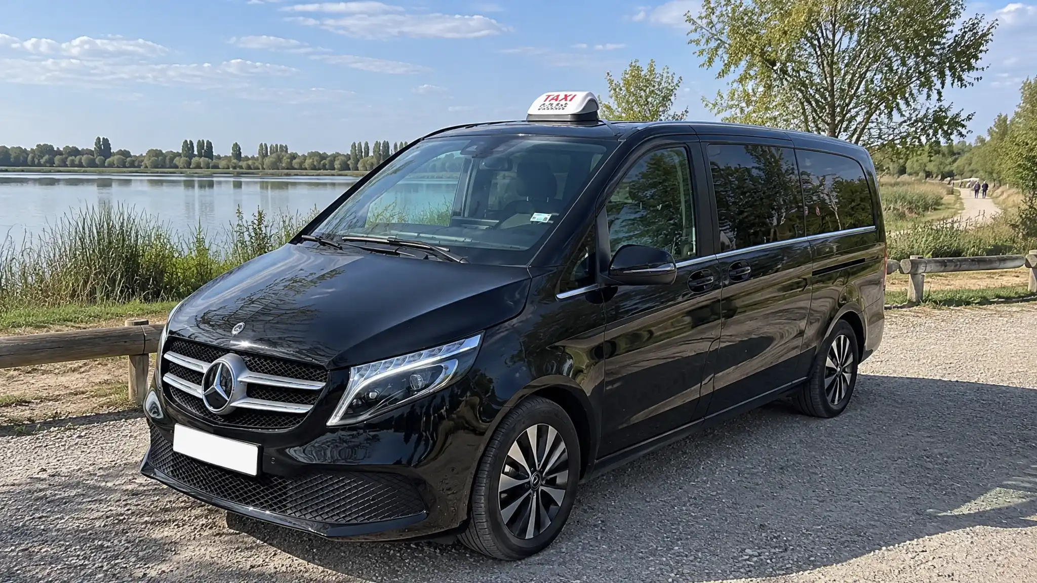 La Classe V de VK Taxi au bord d’un grand lac bordé de roseaux et de peupliers, un matin d’été