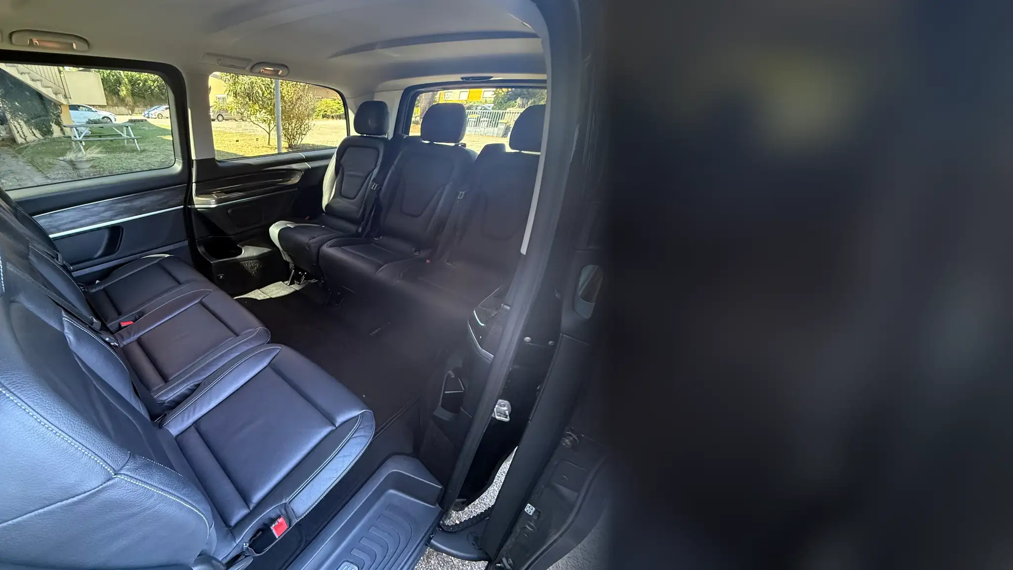 L’intérieur du Classe V de VK Taxi et Services, porte ouverte : deux rangs de sièges en cuir face à face