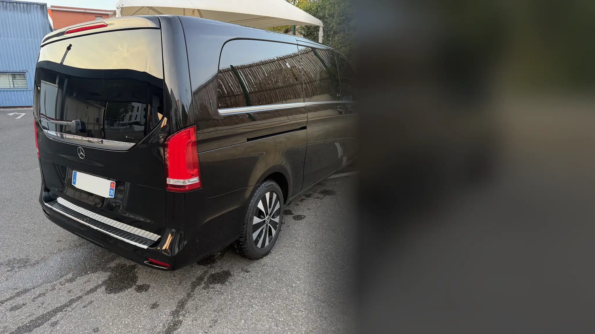 Le Classe V noir de VK Taxi et Services vu de trois quarts arrière, sur un parking