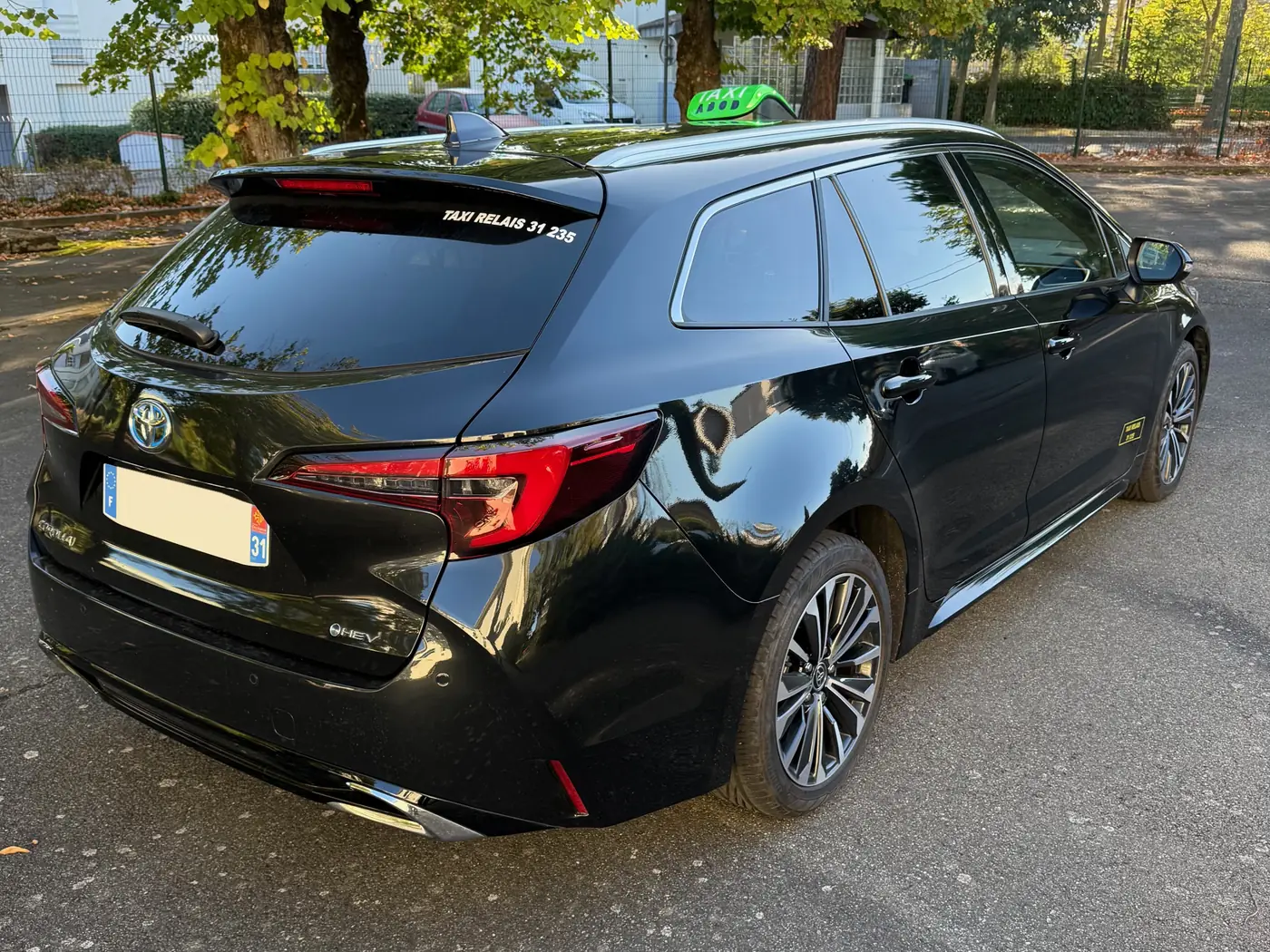 L’arrière du taxi relais de VK Taxi et Services, l’autocollant « TAXI RELAIS 31 235 » en haut de la lunette arrière