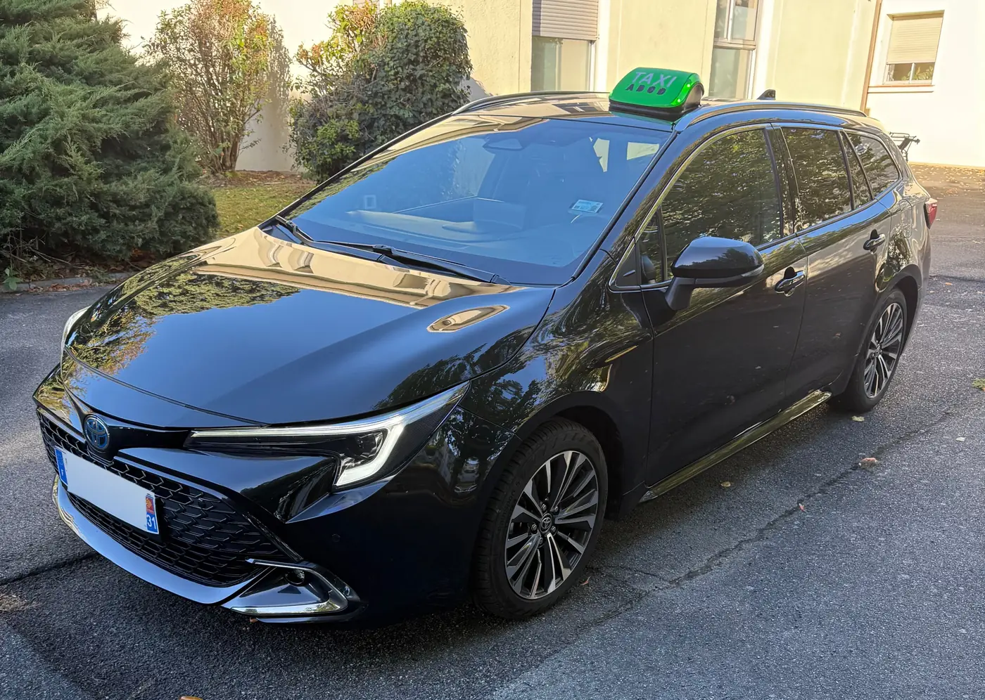 Le taxi relais de VK Taxi et Services, une Toyota Corolla break hybride noire, lumineux TAXI sur le toit