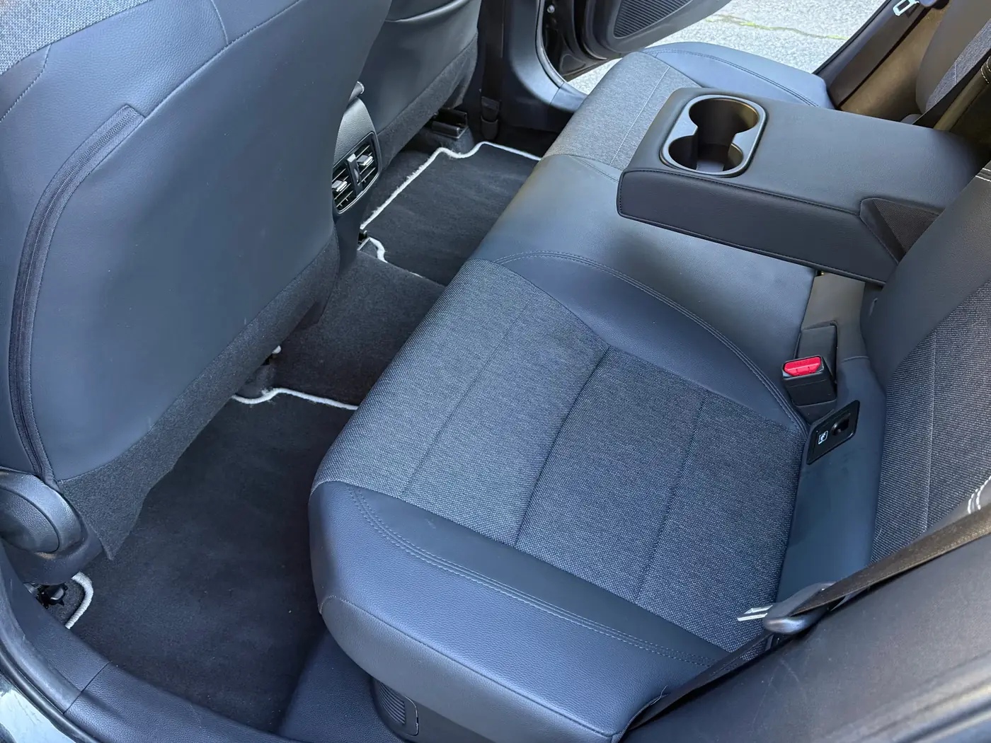 La banquette arrière du taxi relais de VK Taxi et Services, accoudoir central et porte-gobelets, tapis propres