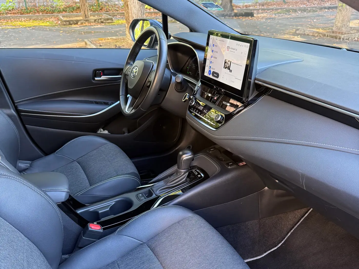 Le poste de conduite du taxi relais de VK Taxi et Services : volant, grand écran central, boîte automatique, sièges en tissu et simili